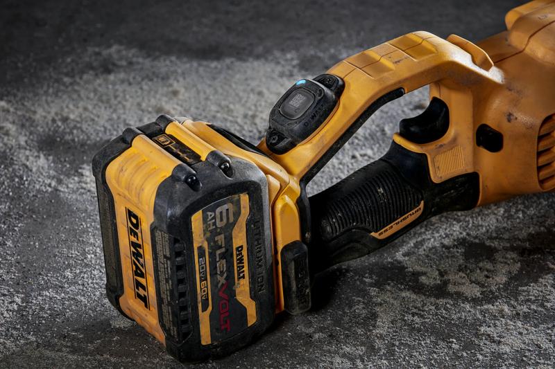 Close-up of a DEWALT cordless power tool with a FlexVolt 6 Ah battery attached, showing the handle and battery on a concrete surface.