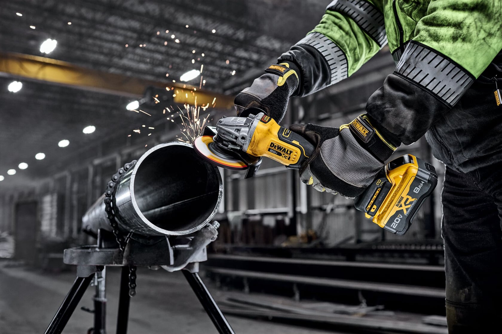 DEWALT 20V MAX* XR®  4-1/2 in. - 5 in. Angle Grinder grinding metal pipe in a commercial setting. 