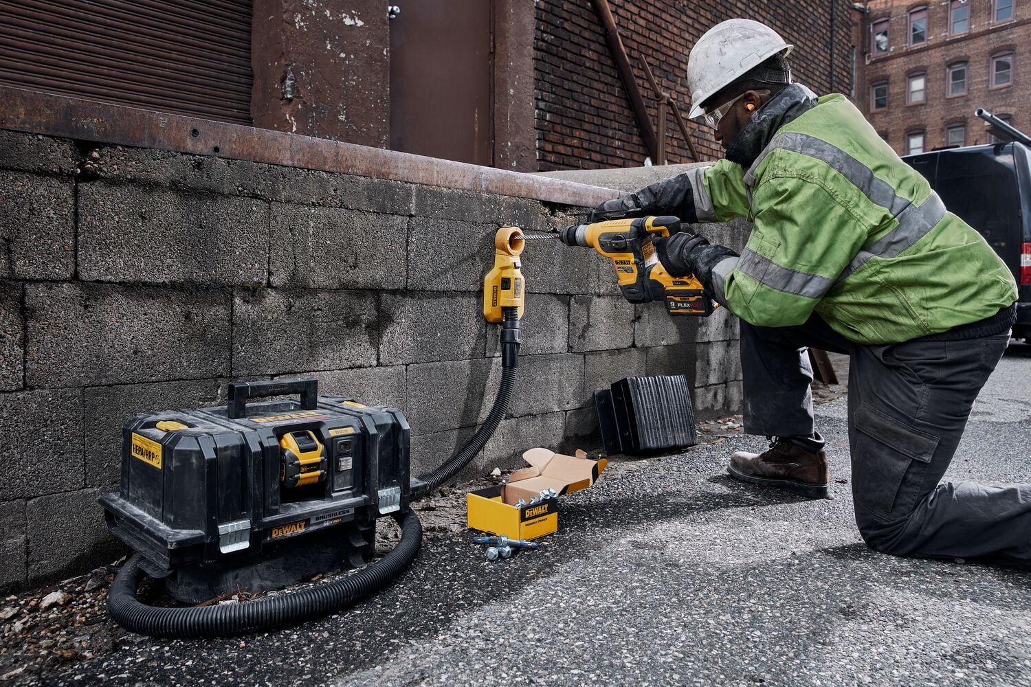 60 Volt MAX 1 and quarter inch Brushless S D S PLUS Rotary Hammer kit being used for drilling hole concrete wall by person.
