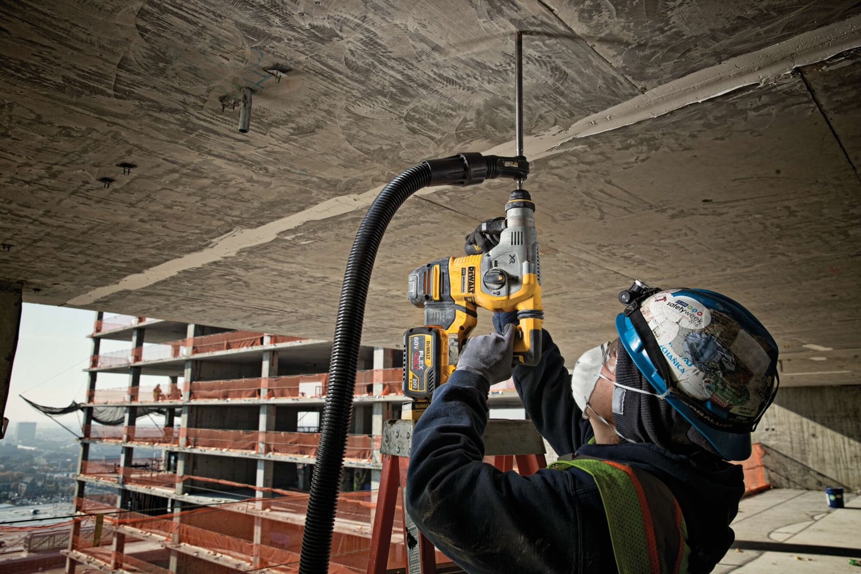 Brushless, cordless SDS PLUS L-shape rotary hammer being used by a person