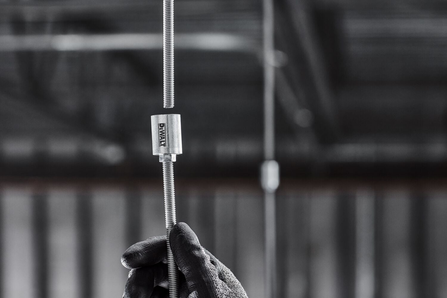 DEWALT PFM3613038 Coupler is attached to a hanging threaded rod in a mechanical room.