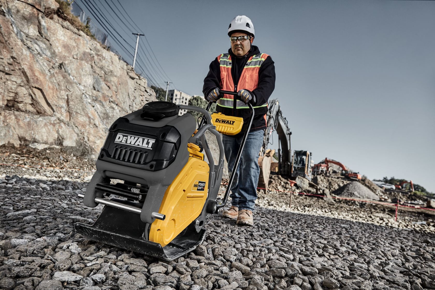 Man running plate compactor