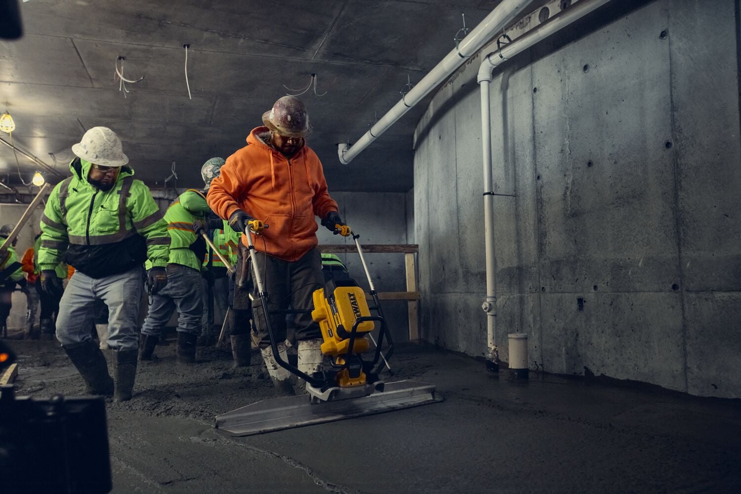 DEWALT POWERSHIFT™ screed smoothing concrete in confined space with concrete crew