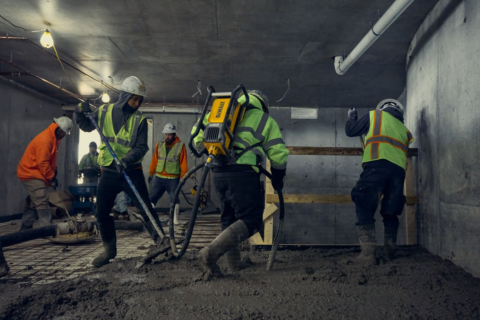 Concrete crew using DEWALT POWERSHIFT backpack vibrator in a small space