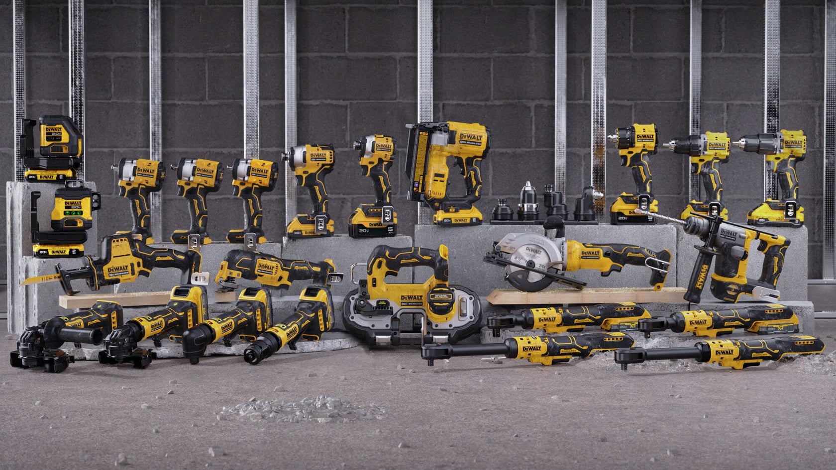 A collection of various DEWALT cordless power tools displayed against a construction site background, including drills, saws, grinders, and other hand tools. All tools are yellow and black in color.