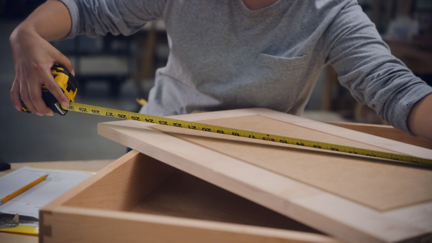 A carpenter uses a tape measure