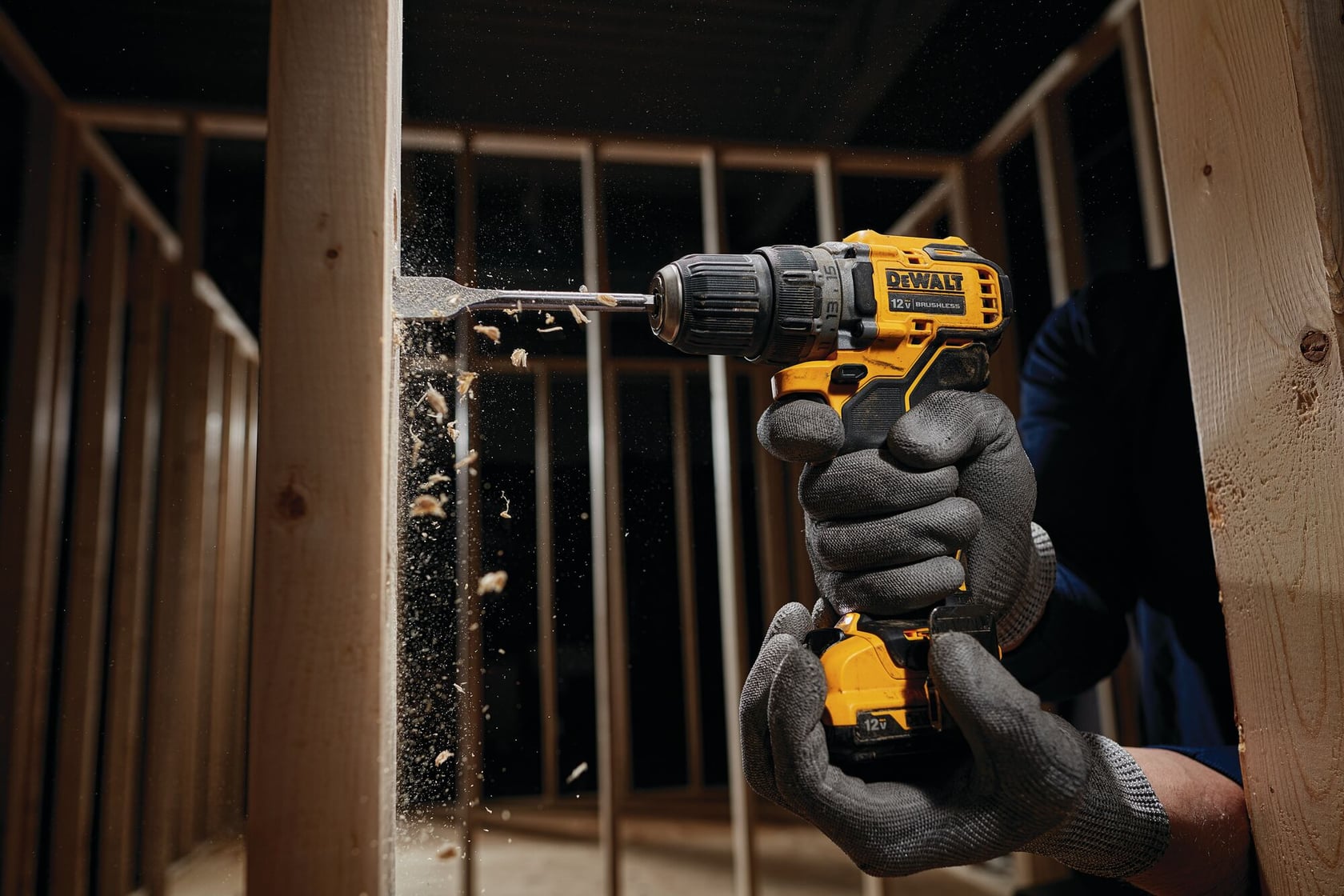 Brushless cordless drill driver with battery drilling wooden frame.